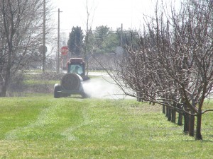Tractor spraying fertilizer on field